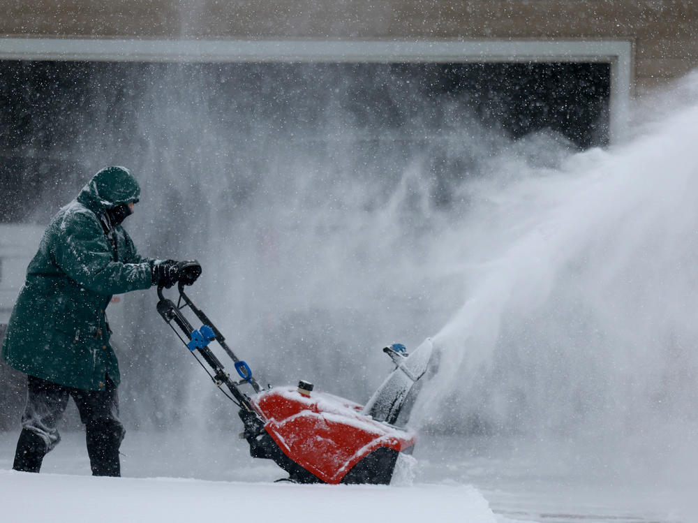 Linda Rae uses a snowblower to clear her driveway during a  snowstorm on Friday in Des Moines, Iowa.