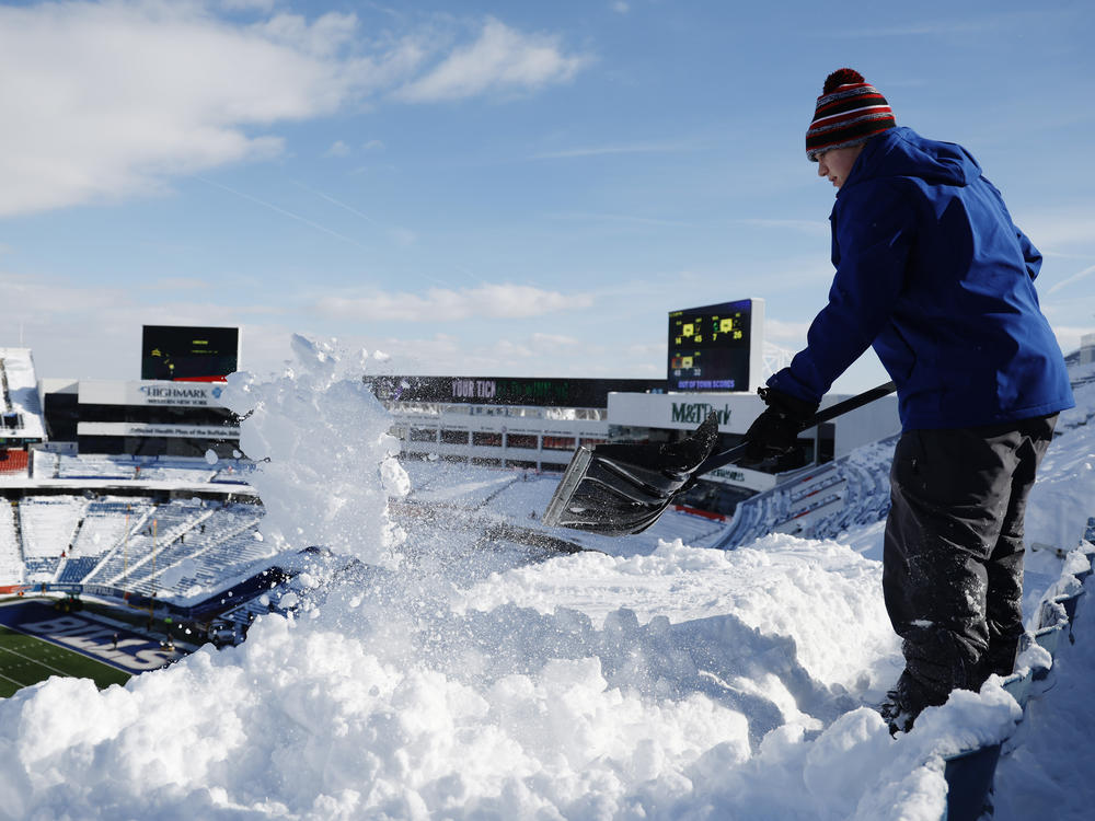 Brady Reinagel shovels snow before the AFC Wild Card playoff game between the Buffalo Bills and Pittsburgh Steelers at Highmark Stadium in Buffalo, N.Y. The Bills hired local residents to help clear snow from the stadium before Monday's game.