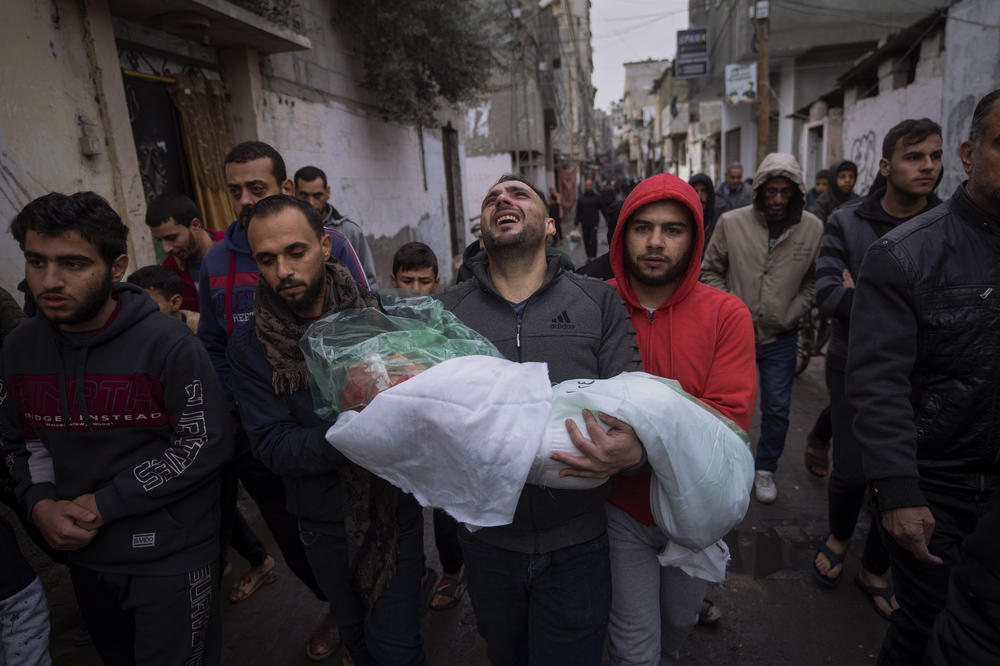 Mohammad Shouman carries the body of his daughter, Masa, who was killed in an Israeli bombardment of the Gaza Strip, during her funeral in Rafah on Jan. 17.
