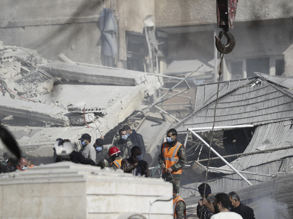 Emergency services work at a building hit by an air strike in Damascus, Syria, on Saturday.