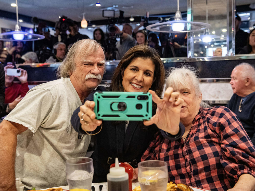 Former U.N. ambassador and 2024 Republican presidential hopeful Nikki Haley takes a selfie with voters at Mary Anne's Diner in Amherst, N.H.