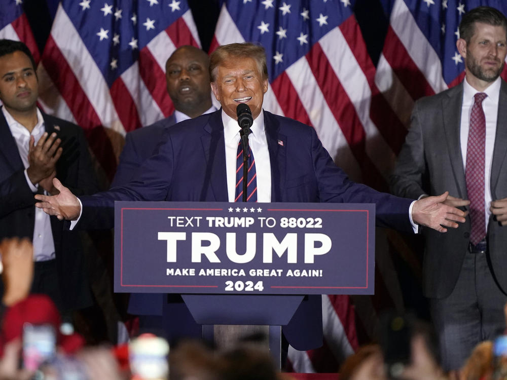 Former President Donald Trump speaks at a primary election night party in Nashua, N.H., on Tuesday as Vivek Ramaswamy, Sen. Tim Scott, R-S.C., and Eric Trump watch.