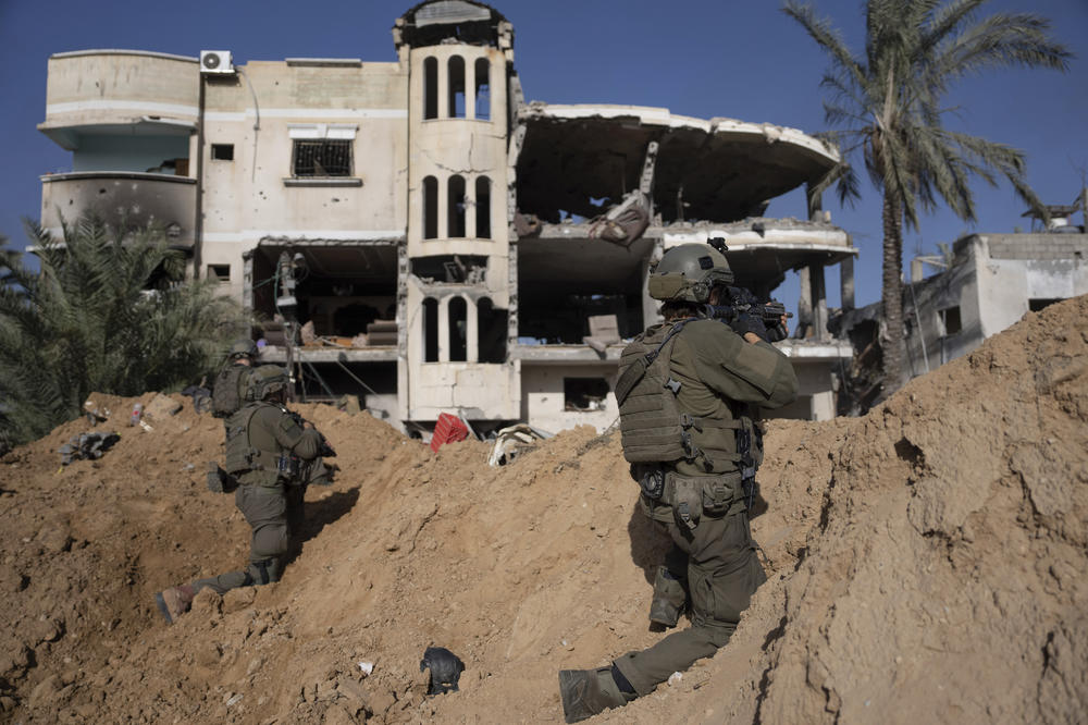 Israeli soldiers take up positions next to a destroyed building during a ground operation in Khan Younis, Gaza on January 10.