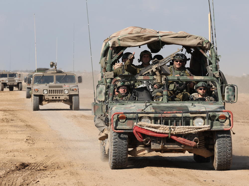 Israeli army troops drive through a dirt road along the border with Gaza in southern Israel on January 25.