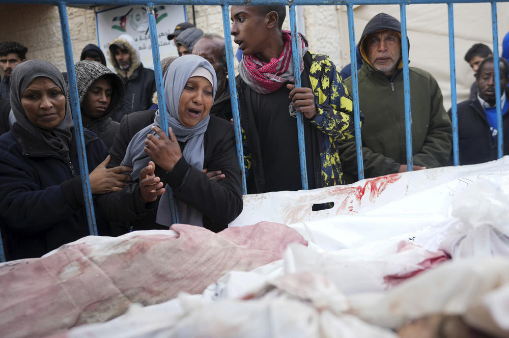 Palestinians mourn the relatives killed in the Israeli air and ground offensive on the Gaza Strip at a hospital in Deir al Balah on Jan. 26.