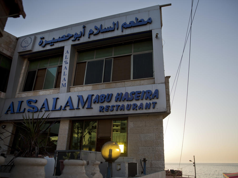 The sun sets over Al Salam Abu Haseira fish restaurant by the beach in Gaza City, in 2019.