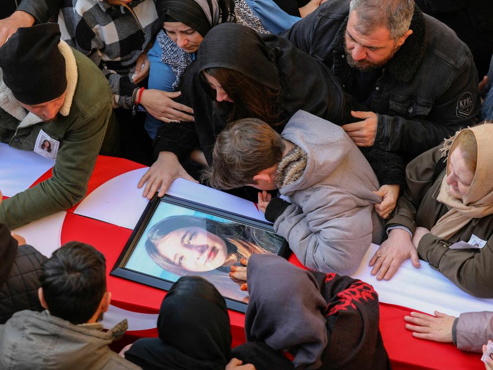 People mourn by a coffin during the funeral of Cypriot students killed in an earthquake that hit Turkey, in the eastern city of Famagusta, in the breakaway Turkish Cypriot statelet of northern Cyprus, on Feb. 11, 2023.