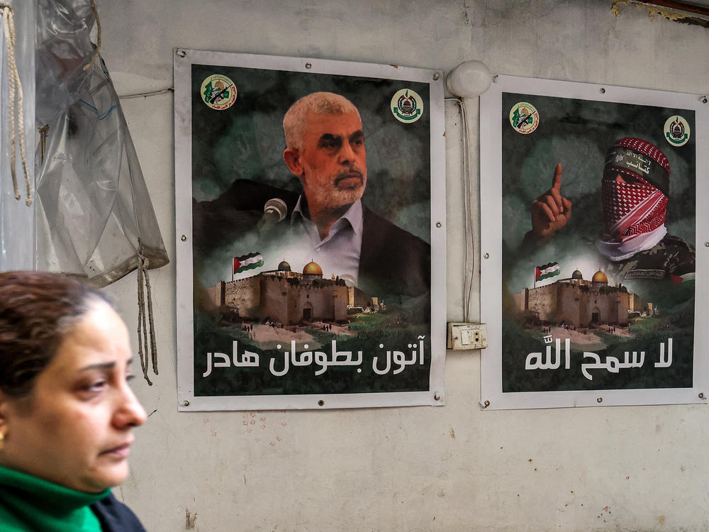 A woman walks past posters depicting Yahya Sinwar, the head of Hamas in Gaza, plastered on a wall in the Burj al-Barajneh camp for Palestinian refugees in Beirut's southern suburb on Feb. 5.
