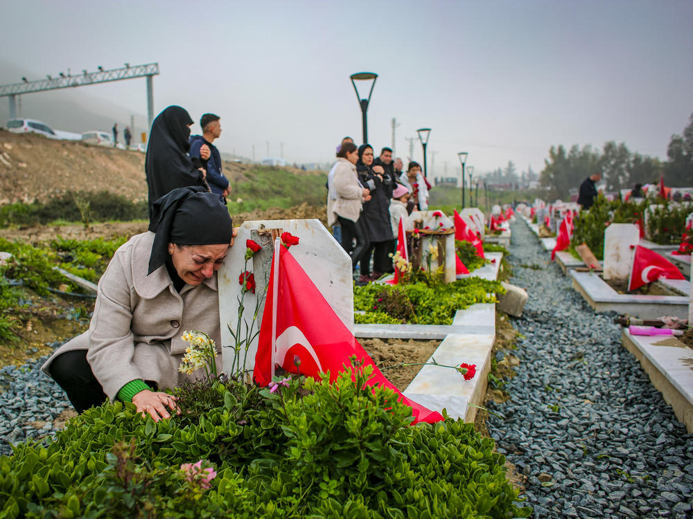 A women crying over a relative's grave in a cemetery on Tuesday, marking the first anniversary of the Feb. 6, 2023, earthquake that devastated parts of Turkey and Syria.