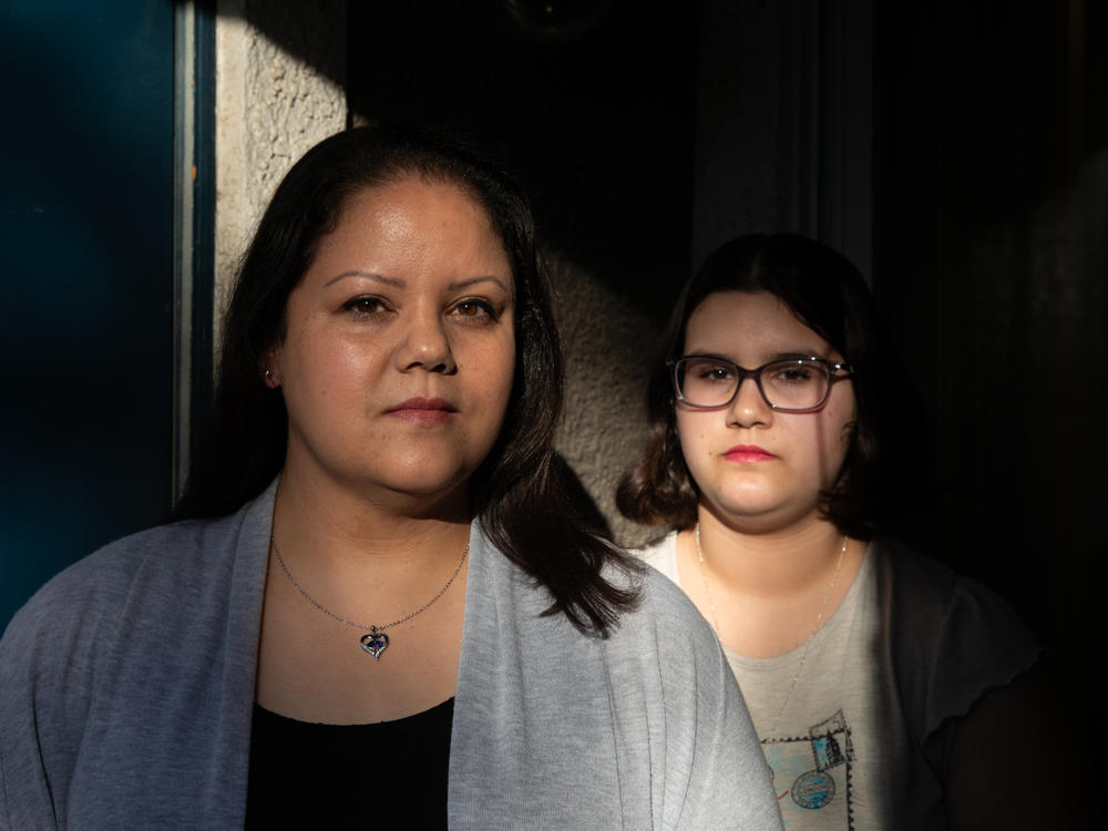 Amber Ayala stands with her daughter outside their home in Las Vegas.