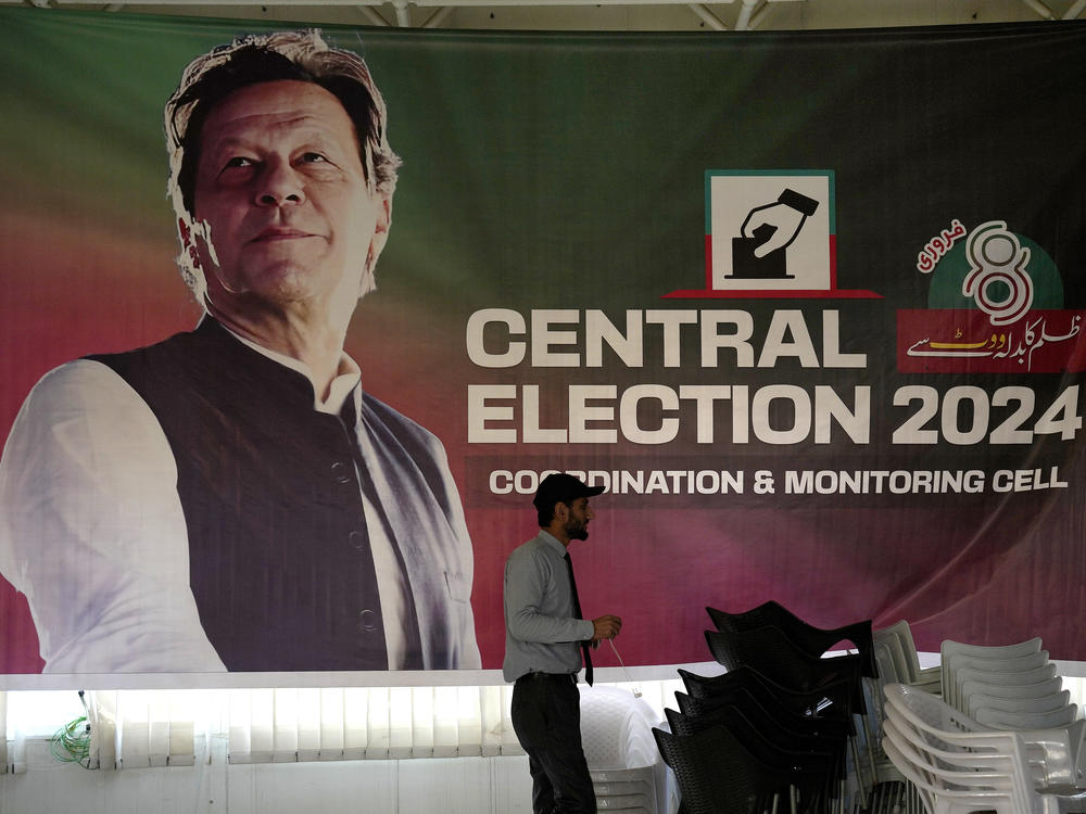 A supporter walks past a poster of Pakistan's imprisoned former prime minister, Imran Khan, displayed at his party office in Islamabad, Pakistan, Friday.