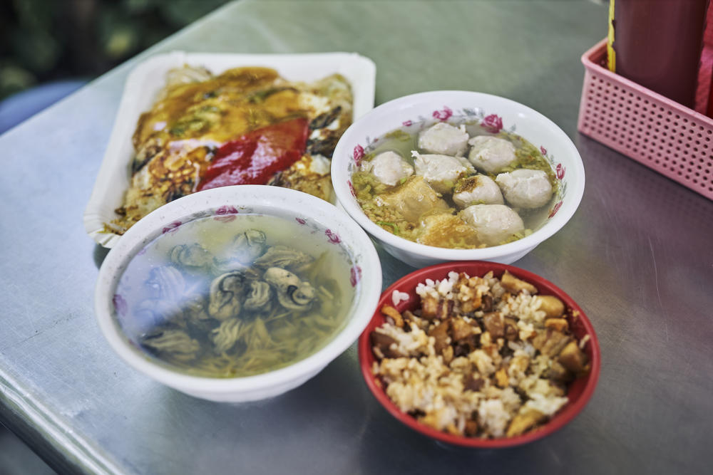 A set of traditional Taiwanese cuisine staples: oyster omelet, lu rou fan, oyster soup and fish ball soup.