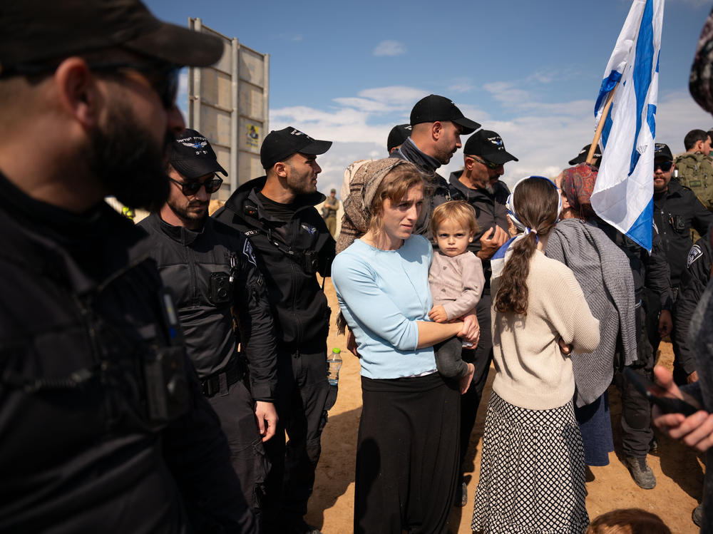 Israeli border police watch over protesters attempting to block the road at the Kerem Shalom border crossing, where Israel inspects trucks and allows them to cross into the Gaza Strip.