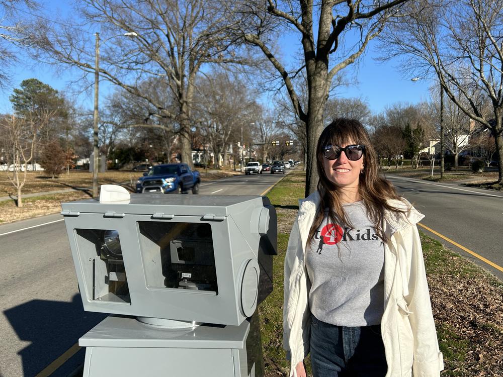Safety advocate Tara FitzPatrick stands next to a new automated speed camera in Richmond, Va.