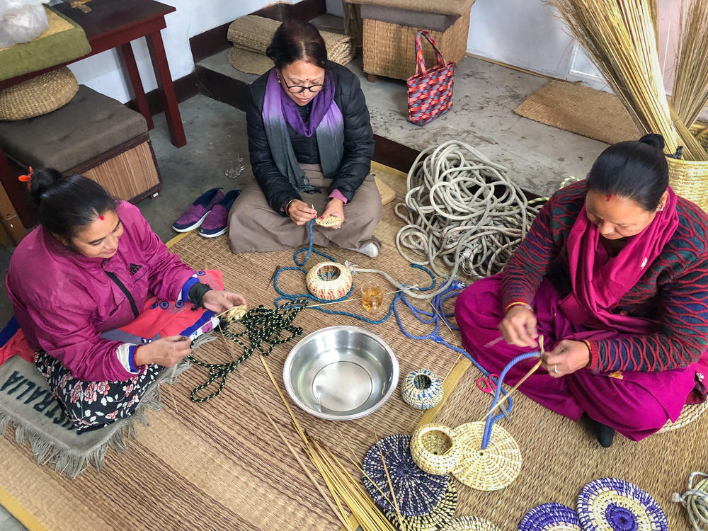 Sunita Kumari Chaudhary with fellow crafters in the Nepal Knotcraft Center's workspace in Lalitpur. The women's earnings are based on their output and average out to a bit above Nepal's minimum wage.