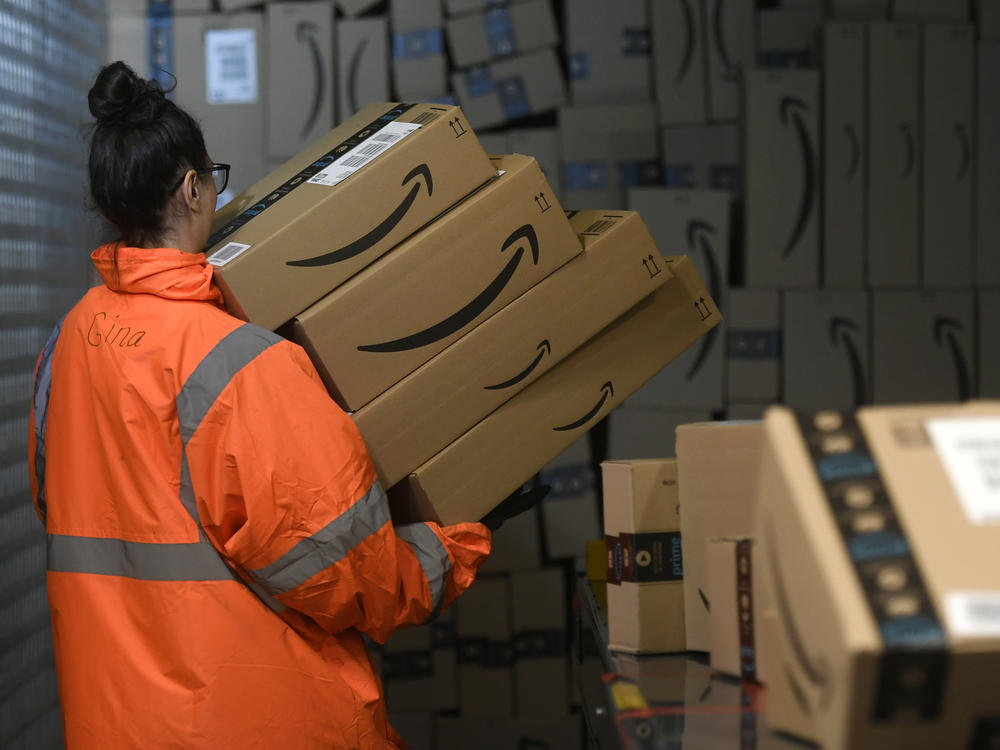 An employee handles customer packages at the distribution center of the U.S. online retail giant Amazon, in Germany.