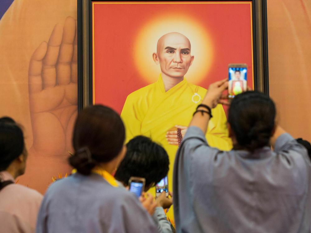 People take pictures of a portrait of Thich Quang Duc, the monk who set himself on fire on a busy Saigon street corner in 1963, at the Vietnam Quoc Tu pagoda in Ho Chi Minh City on June 3, 2018. Vietnam marked the 55th anniversary of the self-immolation by the monk whose fiery protest came to symbolize the repression of the U.S.-backed South Vietnamese regime against Buddhism.