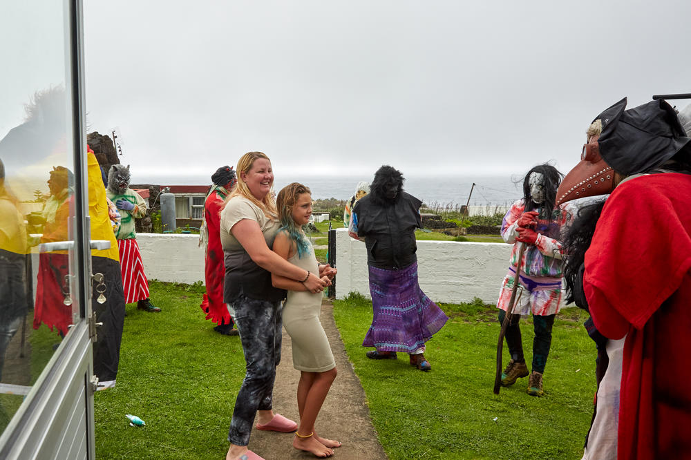 Tristan da Cunha's Head of Tourism, Kelly Green, greets the Okalolies with her daughter Savanna after they've arrived at their home. Moments after this image was taken, Kelly was soaked with water from a garden hose. Kelly's husband, Shane, was one of the Okalolies, and Kelly had trouble figuring out who her husband was before he finally revealed himself.