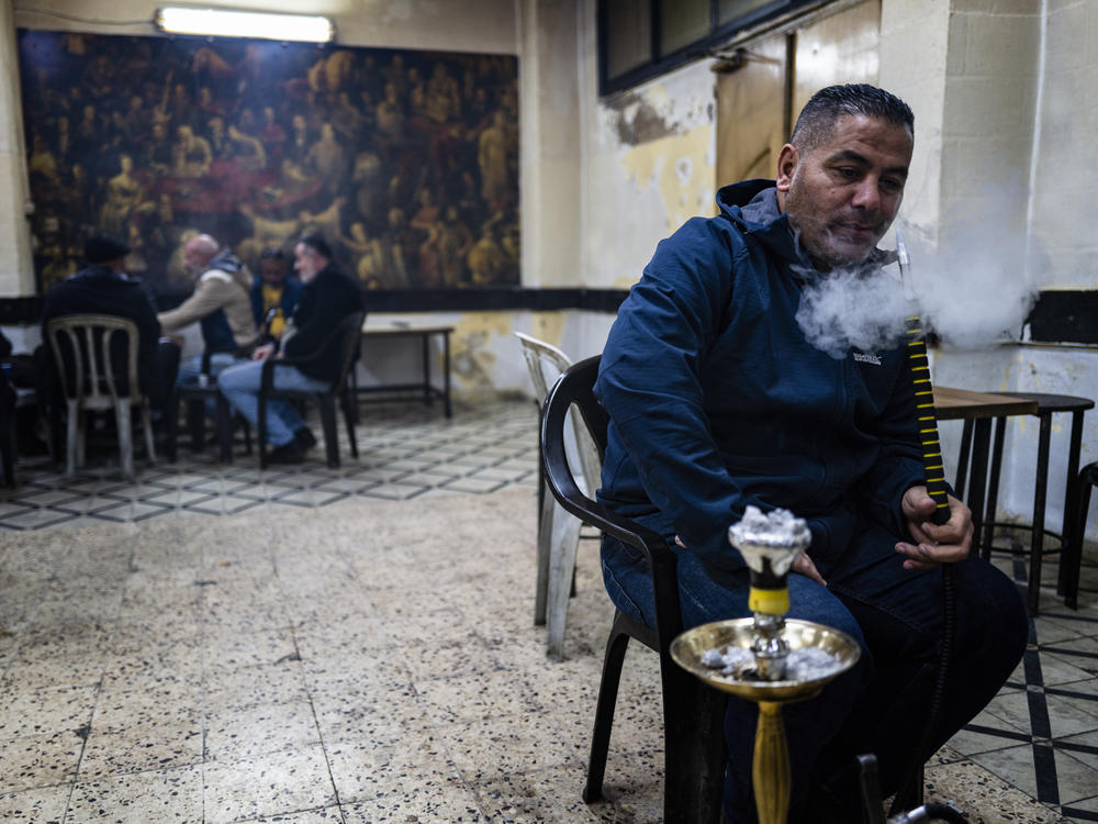 Men smoke, play cards and talk politics inside a cafe in the Ama'ari refugee camp, just outside Ramallah, earlier this month. In the occupied West Bank, there is deep dissatisfaction with the Palestinian Authority.