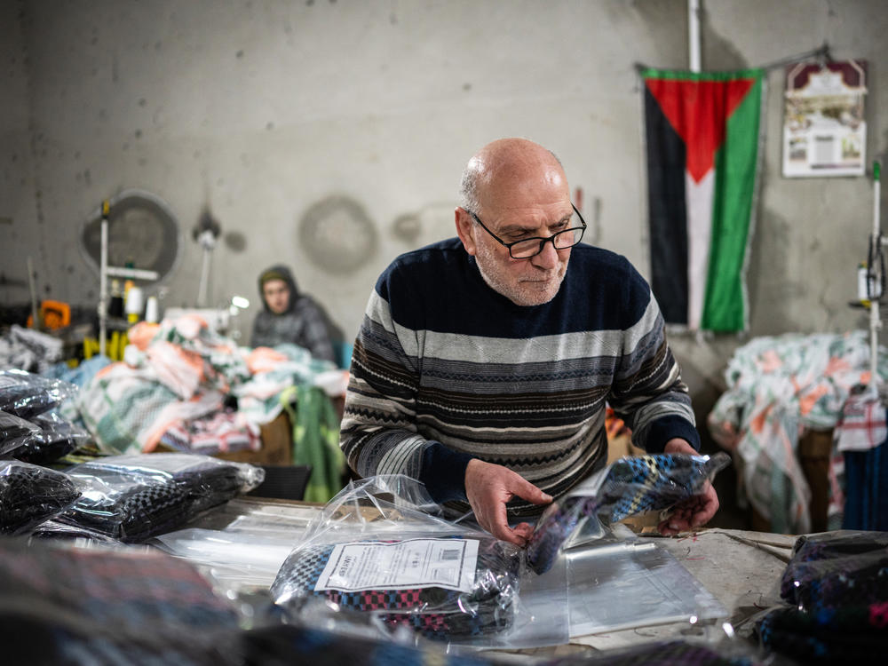 Judeh Hirbawi packages keffiyehs at the Hirbawi keffiyeh factory, which has seen an increase in sales since the start of the Israel-Hamas war, in Hebron, West Bank, on Feb. 11, 2024. Hirbawi is one of three brothers who own and run the factory that their father started.