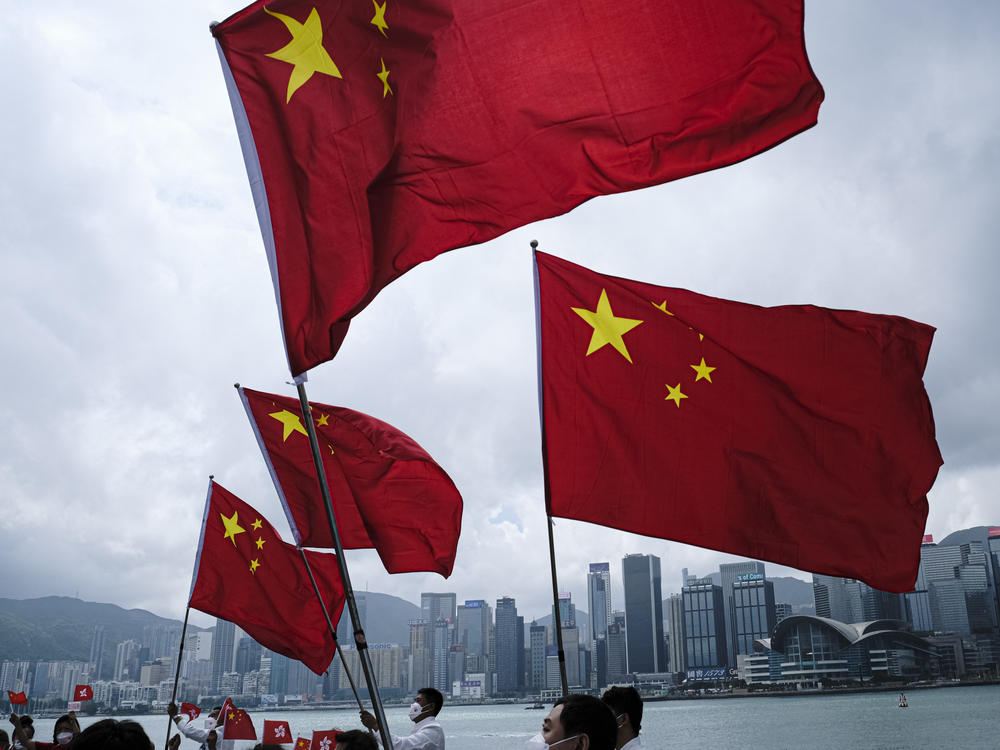 People wave the flag of China in Hong Kong on Oct. 1, 2022. Recently, lawmakers in Hong Kong passed a controversial new national security law, that some worry could dent Hong Kong's standing as a global financial hub.