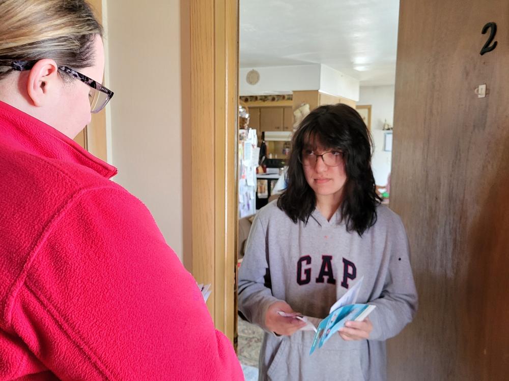 Biden campaign volunteer Sarah Harrison speaks with voter Autumn Dietscher on March 16 about Waukesha School Board elections and Wisconsin's presidential primary.