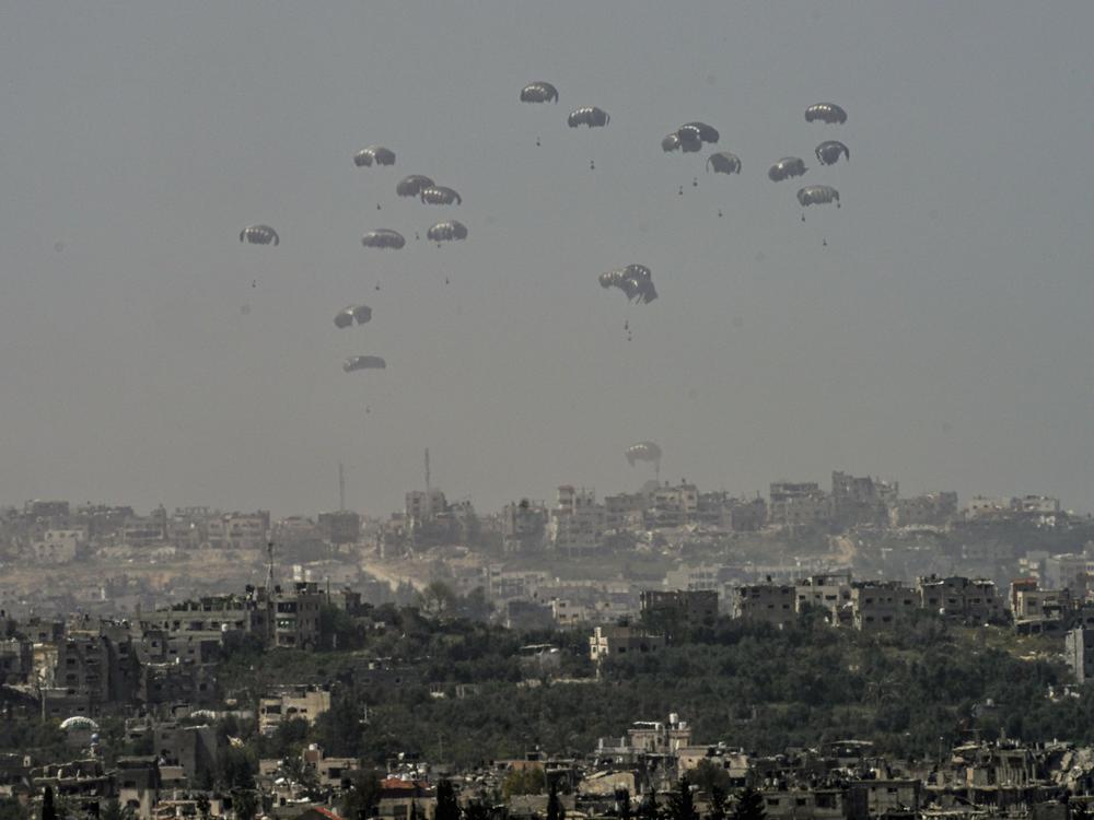 An aircraft airdrops humanitarian aid over the northern Gaza Strip, as seen from southern Israel, Sunday, March 31, 2024.