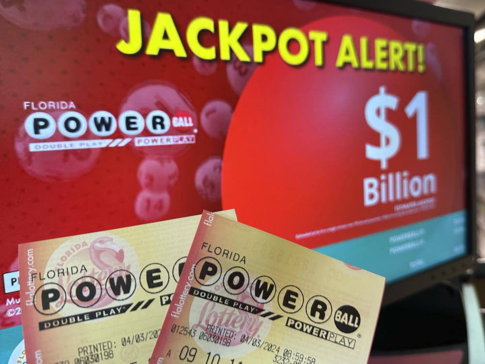 Powerball tickets are shown in front of a screen displaying the estimated jackpot, Wednesday, April 3, 2024, in Surfside, Fla.