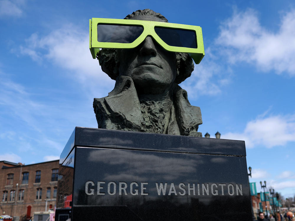 Eclipse glasses are worn by a statue of George Washington on Sunday in Houlton, Maine.