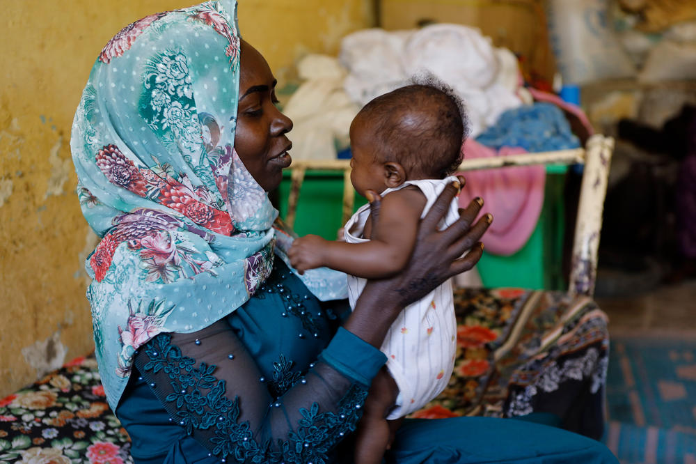 Maryam holds the 7-month-old child she gave birth to inside a refugee camp in Gezira, Sudan, on Dec. 10, 2023. She says 