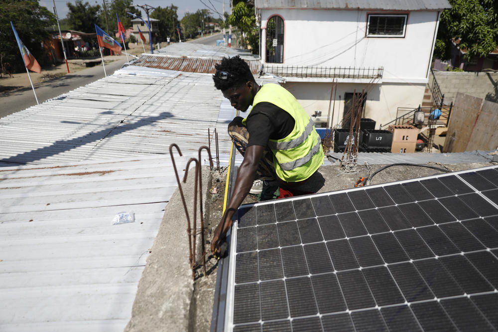 Rod Augustin measures dimensions for solar installation at a bar in Limonade, Haiti, on March 17, 2024.