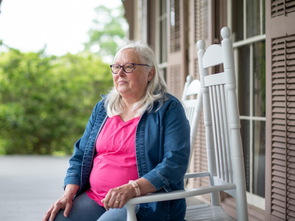 Susan Campbell, a local historian, sits on the front porch of Fendall Hall. She says she'd like to see more information about the Young-Dent family included on the historical marker at the mansion.