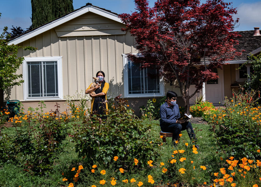 Nitya and Arvind Kansal pose with their dog, Kuku, in front of their Cupertino, Calif., home in April 2020. 