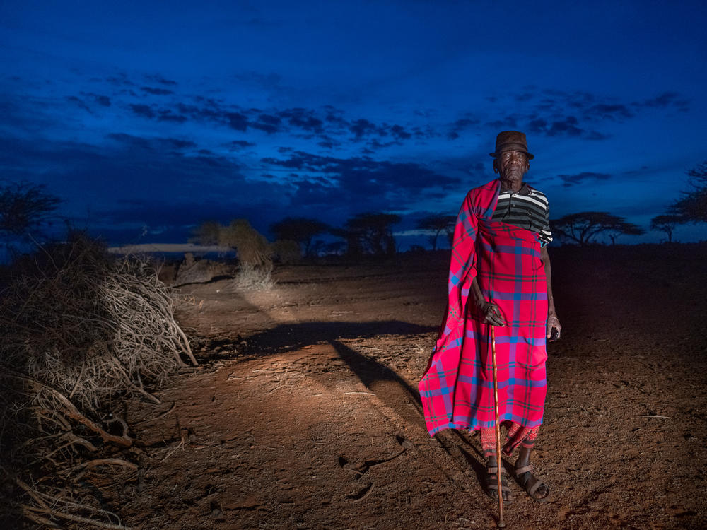 Samburu elder Francis Lengees stands near his home. In the late 1970s, he and fellow herders helped build the first structures for the primary school that Paris and his two moran 
