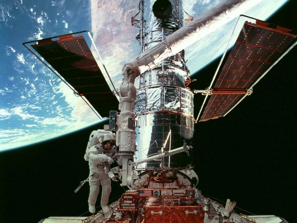 In a 1997 servicing mission, astronaut Steven Smith does a spacewalk as the telescope sits in space shuttle Discovery's cargo bay.