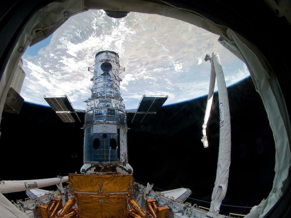 The Hubble Space Telescope in 2009, locked in a space shuttle's cargo bay, before the final repair work ever done.