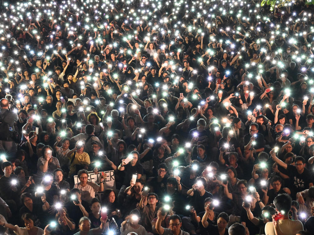Demonstrators hold up lights from their phones during a rally organized by Hong Kong mothers in support of extradition law protesters, in Hong Kong on July 5, 2019.