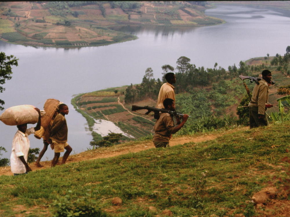 In 1994, refugees and a soldier walk in the foothills of Lake Kivu on a route between Gisenyi and Ruhengeri, in Rwanda.