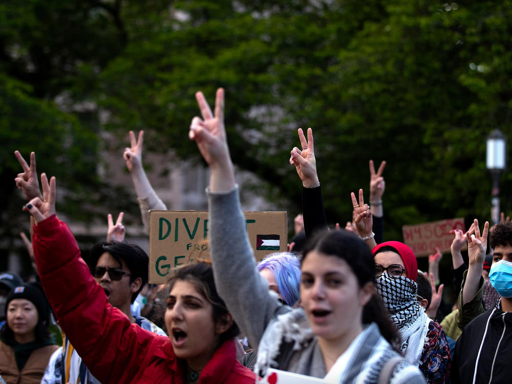 Students and protesters raise peace signs in the air while listening to speakers at the encampment for Palestine on Tuesday, May 7, 2024, at the University of Washington Quad in Seattle. Large crowds amassed ahead of a speech by Turning Point USA founder Charlie Kirk at the HUB on UW's campus.