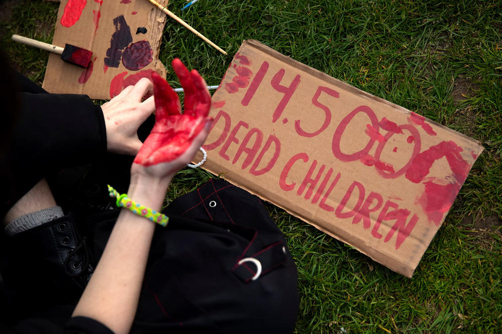 '14,500 dead children' is written in red paint on a handmade sign within the 'Popular University for Gaza liberated zone,' on Tuesday, May 7, 2024, at the University of Washington campus Quad in Seattle.