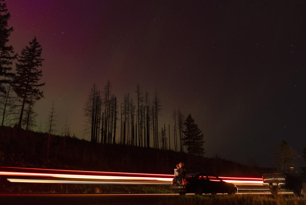 Estacada, Ore.: In this image taken with a long exposure, cars pass by as people look at the night sky towards the northern lights, or Aurora Borealis, on Friday, May 10, 2024, in Estacada, Ore.