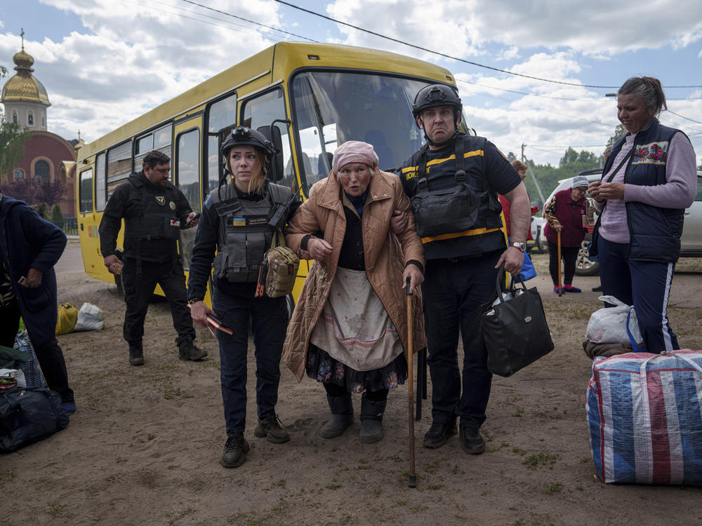 Rescue workers help Liudmila Kalashnik, 88, after evacuation from Vovchansk, Ukraine, on Sunday. Her husband was killed in their house after a Russian airstrike on the city.