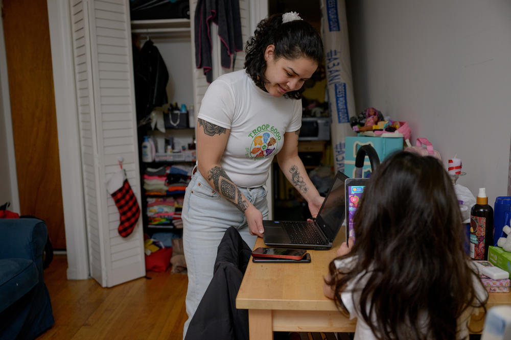 Juliana, a single mother of two, gets ready to lead a Troop 6000 virtual meeting from her basement apartment in Manhattan. Both her daughters, pictured Any, attend virtually as Girl Scouts even after they left the shelter system. Originally from Bogota, Juliana emigrated with her younger sister and two daughters nearly two years ago.