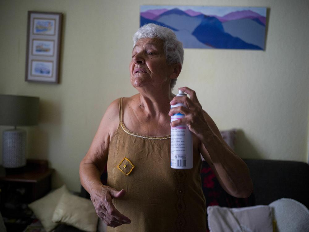 Jackye Lafon, who's in her 80s, cools herself with a water spray at her home in Toulouse, France during a heat wave in 2022. Older people face higher heat risk than those who are younger. Climate change is making heat risk even greater.