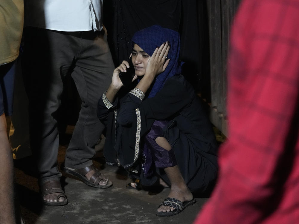 A girl whose relative is missing speaks on the phone at the site of a collapsed billboard following heavy rain and thundershowers in Mumbai, India, on Monday.
