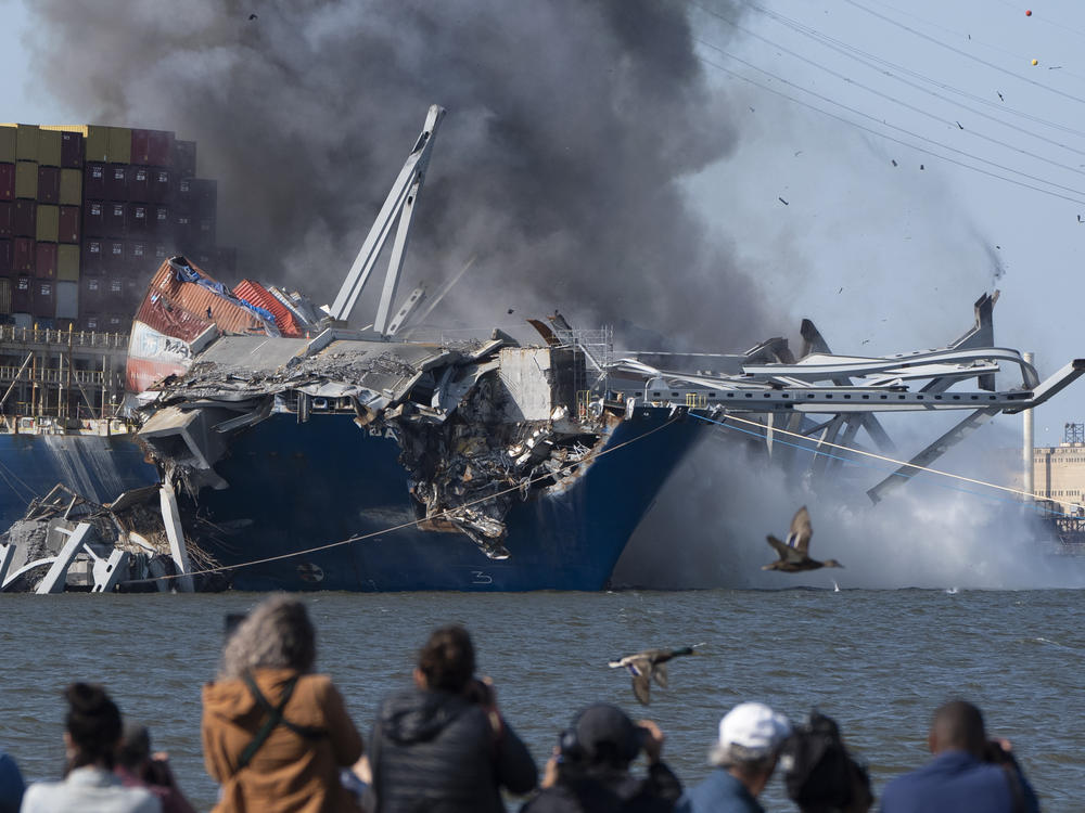Explosive charges are detonated to bring down sections of the collapsed Francis Scott Key Bridge resting on the container ship Dali on Monday in Baltimore.