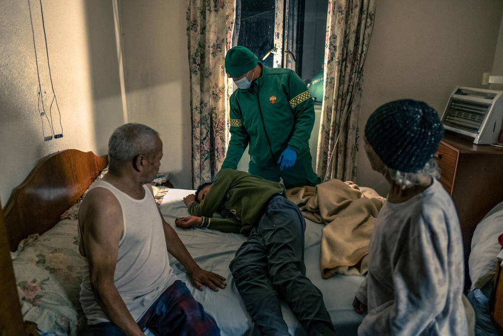 Paramedic Igshaan Adriaanse checks on a patient suspected to have taken a drug overdose.