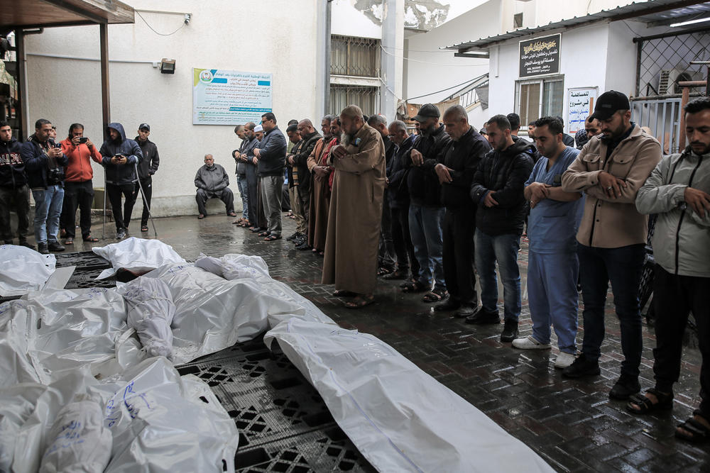 Palestinians perform funeral prayer by the shrouded bodies of people killed in Israeli attacks after taking the bodies out of the Mohammed Yousef El-Najar Hospital mortuary for burial in Rafah, Gaza, on May 6.