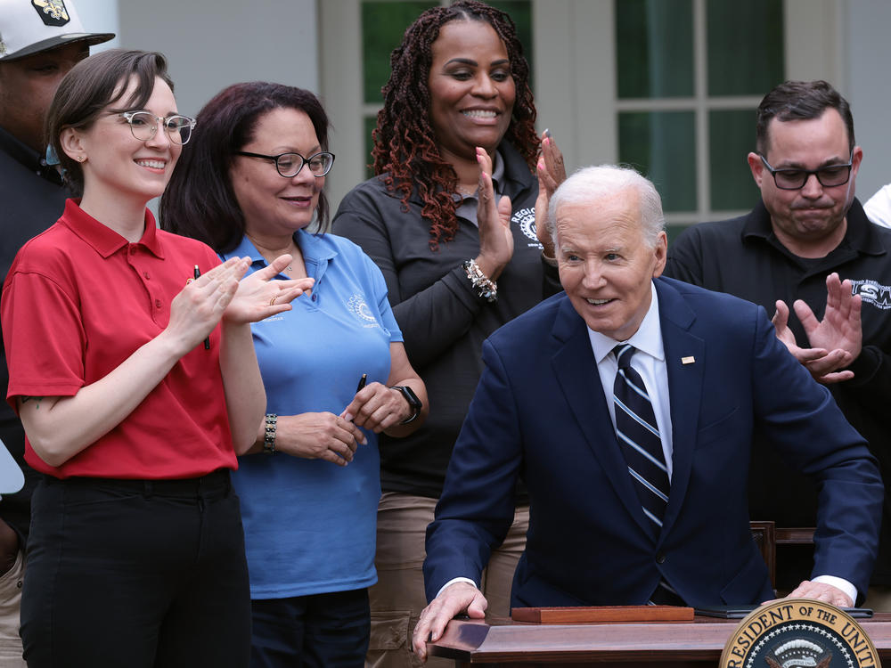 Flanked by union members, President Biden signs orders that increase tariffs on imports of electric vehicles and other strategic goods from China.