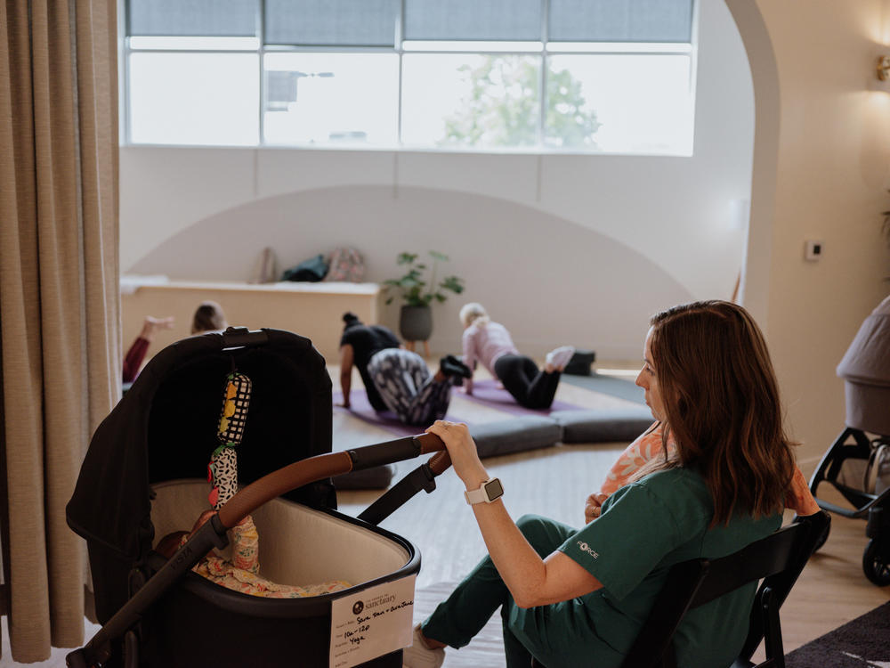 While parents participate in a movement class, postpartum doulas care for their newborn babies.